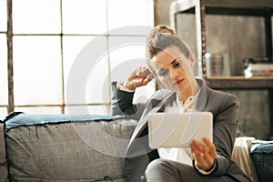 Thoughtful business woman using tablet pc