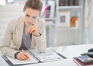 Thoughtful business woman working with documents