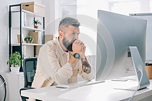 Thoughtful businessman with clenched hands sitting