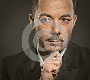 Thoughtful businessman. Handsome serious man touching his chin with hand. Close up portrait of mid age caucasian white