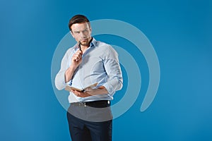 thoughtful businessman holding notepad and pen