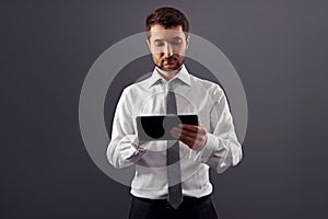 Thoughtful businessman holding tablet pc