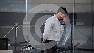 Thoughtful Businessman Pacing Near the Window in the Office