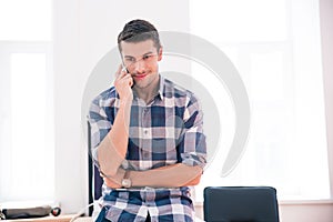 Thoughtful businessman talking on the phone in office