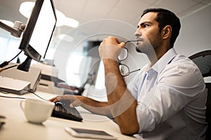 thoughtful businessman using computer at office desk