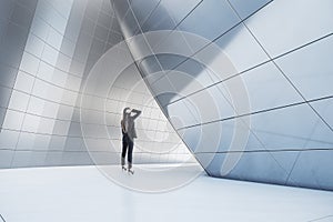 Thoughtful businesswoman standing in abstract  building open space interior