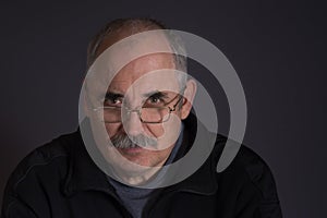 Thoughtful Caucasian man against dark background