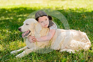 Thoughtful child hugs a dog