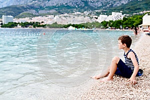 Thoughtful child sitting on the beach