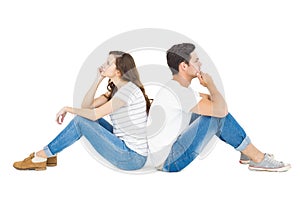 Thoughtful couple sitting on floor back to back