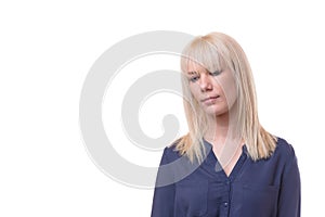 Thoughtful dejected blond woman with downcast eyes