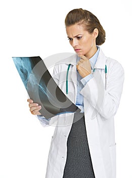 Thoughtful doctor woman looking on fluorography