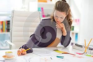 Thoughtful fashion designer working in office