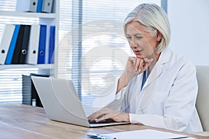 Thoughtful female doctor working on her laptop