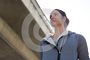 Thoughtful female jogger listening to music