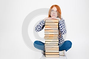 Thoughtful female put head on stack of books