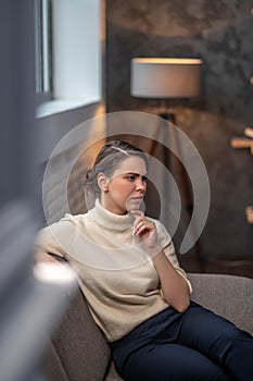 Thoughtful female sitting in a living room