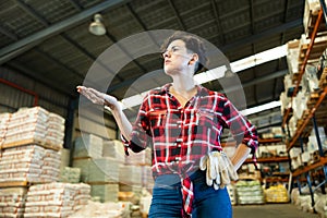 Thoughtful female storekeeper looking for tedious goods in building materials warehouse indoor