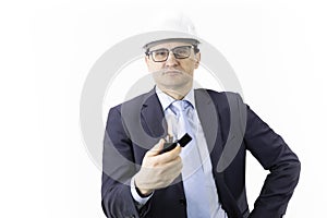 Thoughtful focused on handsome engineer in white helmet holds burning lighter