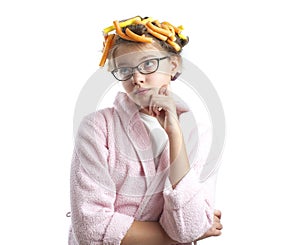 Thoughtful girl in a bathrobe and curlers.