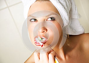 Thoughtful girl brushing her teeth