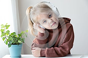 Thoughtful girl listening to music. Melancholic child portrait.Beautiful caucasian toddler sad emotion