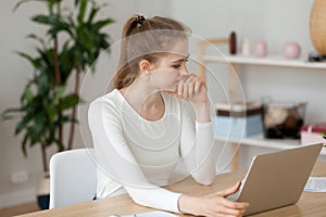 Thoughtful girl look at laptop screen having software problem