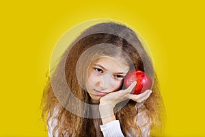 Thoughtful girl with red apple near her head