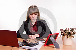 Thoughtful girl sitting at office desk