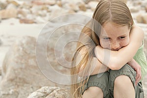 Thoughtful Girl Sitting On Rock