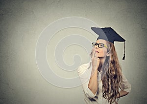 Thoughtful graduate graduated student young woman in cap gown looking up thinking