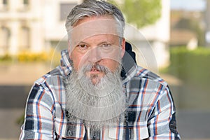 Thoughtful grey-haired man staring at the camera