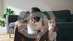 Thoughtful guy embracing dog at sofa room closeup. Artist relaxing after drawing