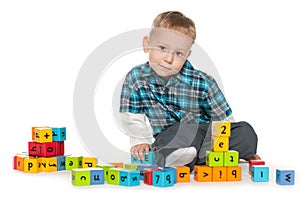 Thoughtful little boy with blocks