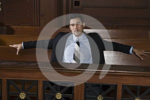 Thoughtful Male Lawyer Sitting In Courtroom