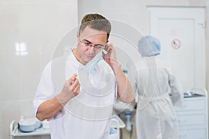 Thoughtful male surgeon wearing surgical mask in hospital