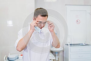 Thoughtful male surgeon wearing surgical mask in hospital