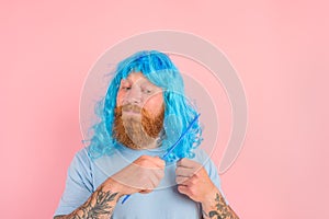 Thoughtful man with beard and blue peruke combs her hair like a woman