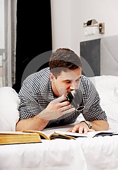 Thoughtful man with a book in his bed.