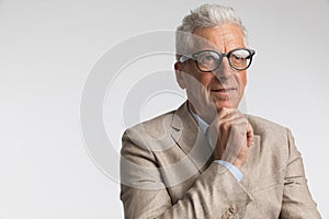 thoughtful man with grey hair wearing glasses and thinking