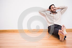 Thoughtful man leaning against wall with crossed arms