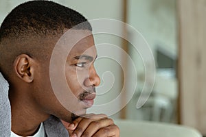 Thoughtful man looking away on bed in bedroom at comfortable home