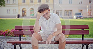 Thoughtful man sitting on bench in park