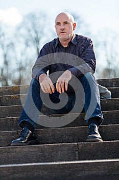 Thoughtful man sitting on a flight of steps