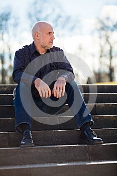 Thoughtful man sitting on a flight of steps