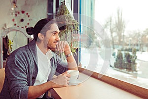Thoughtful man at trendy coffee shop thinking