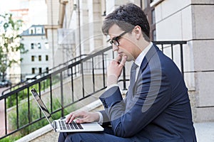Thoughtful man using laptop