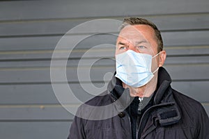Thoughtful man wearing a face mask glancing to the side