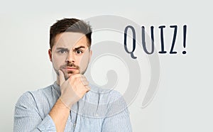 Thoughtful man and word QUIZ on white background