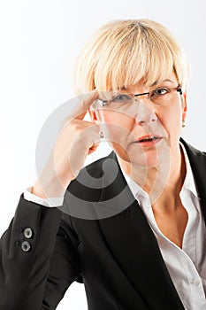 Thoughtful mature businesswoman with eyeglasses